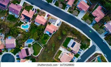 Above View Of Homes And Neighborhoods In The Temecula And Murrieta California In Riverside County With Pools, Solar Panels And Tops Of Roofs With Green Trees And Sun Setting Light. 