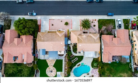 Above view of homes and neighborhoods in the Temecula and Murrieta California in Riverside county with pools, solar panels and tops of roofs with green trees and sun setting light.