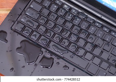 Above View Of Laptop With Water Drop Damage Liquid Wet And Spill On Keyboard, Accident Concept