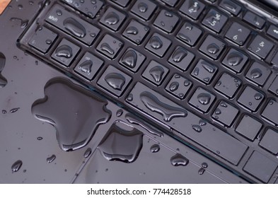 Above View Of Laptop With Water Drop Damage Liquid Wet And Spill On Keyboard, Accident Concept