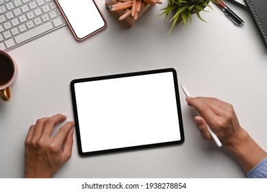 Above view man designer holding stylus pen   working and digital table at white office desk 