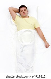 Above view of man with one hand under his head sleeping in cosy bed
