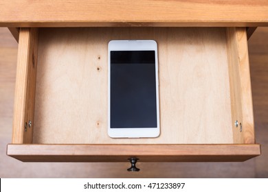 above view of mobile phone in open drawer of nightstand - Shutterstock ID 471233897