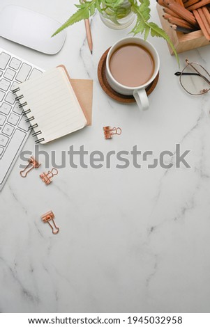 Above view of modern workplace with notebook, glasses, coffee cup and copy space on marble background.