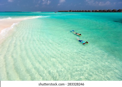 Above view of  mother and son snorkeling in a clear tropical water - Powered by Shutterstock