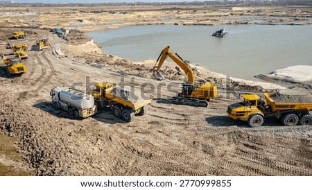 Above view over refuel process, petrol is pouring into the tank, reservoir of large heavy duty dump truck, pour gasoline, diesel in vehicle from truck with cistern, opencast surface sand mining.