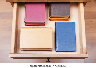 above view of pack ofl little books in open drawer of nightstand - Shutterstock ID 471258353