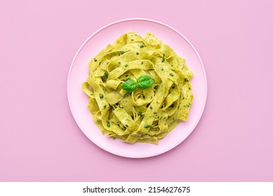 Above view with pappardelle pasta in a pink plate on a pink table. Homemade pasta with with pesto sauce minimalist on a pink background. - Shutterstock ID 2154627675