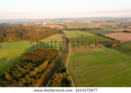 Above view with railtracks passing through nature at sunrise near a german village in Baden Wurttemberg region