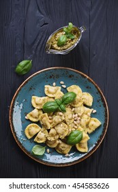 Above View Of Ravioli With Basil Pesto On A Black Wooden Surface