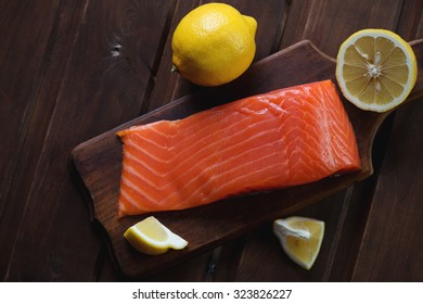 Above View Of Salted Trout Filet With Lemon On A Dark Wooden Surface