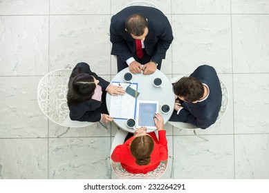 Above View Of Several Business People Are Planning Work At Round Table.