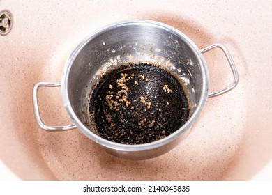 Above View Of Stewpan With Burnt Food In Pink Sink At Home Kitchen