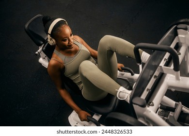 From above view of a strong female athlete practicing legs on a leg press machine at the gym. - Powered by Shutterstock