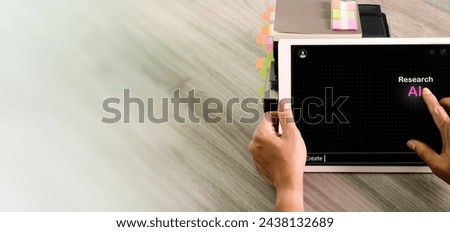 Above view of  student using digital tablet computer asks to AI to research write an homework. Someone uses the  AI chat to drafting a document, he asking to AI to do his job.