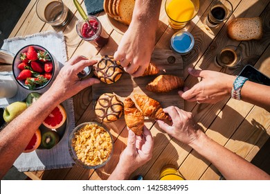 Above View Of Table Full Of Food And People Hands Taking Breakfast Together Like Family Or Friends - Sunny Beautiful Day And Lifestyle Concept For Different Ages Men And Women - Coffee And Fruit Cakes