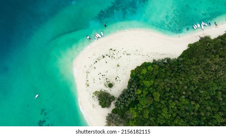 Above View Of  The Tropical Island Beach With  Sand As Seashore As The Tropical Island In A Coral Reef ,blue And Turquoise Sea With The Boats Background