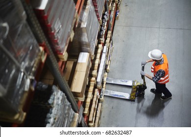 Above view of warehouse loader using forklift cart to pick up pallet with goods