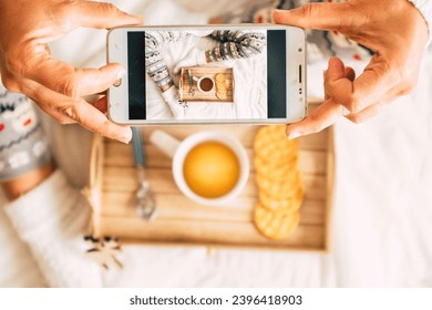 Above view of woman taking food picture of morning breakfast sitting on bed. White copy space of people having photo of coffee and cakes. Christmas holiday leisure activity at home female waking up - Shutterstock ID 2396418903