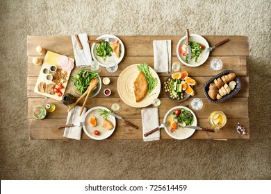 Above View Of Wooden Dinner Table With Half-eaten Dishes Left On It, No People