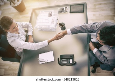 Above view of young consultant shaking hands with customer