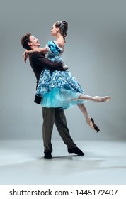 Above The World. Beautiful Contemporary Ballroom Dancers Isolated On Grey Studio Background. Sensual Proffessional Artists Dancing Walz, Tango, Slowfox And Quickstep. Flexible And Weightless.