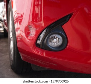 Abrasions and dents on the front bumper  Of red cars after a slight collision accident