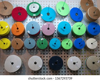 Abrasive Circles For Industrial Equipment Power Tools For Grinding, Cutting Or Polishing At DIY Hardware Store Warehouse. Different Colors For Various Grain