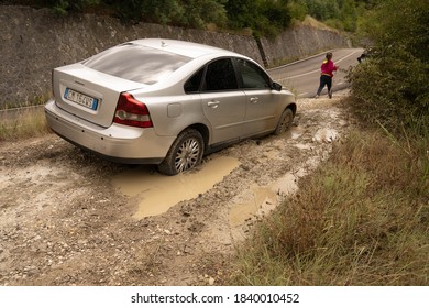 Abruzzo, Italy - July 18, 2020, Silver Car And A Person Stuck Deep In Mud In Abruzzo, Italy