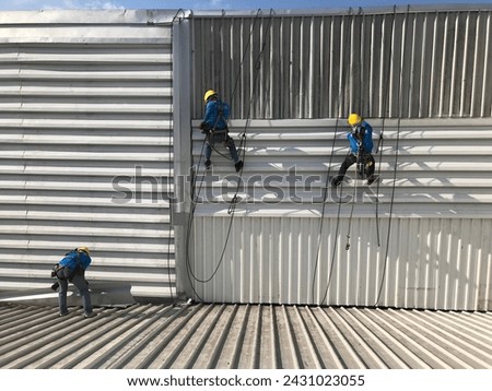 Abseiling from a tall building using a rope.