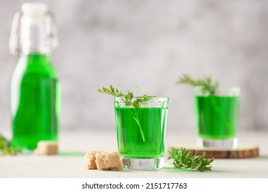 Absinthe drink in glass on light background with the absinthe plant and sugar