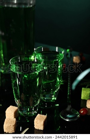 Absinthe in shot glasses brown sugar and spoon on mirror table. Alcoholic drink