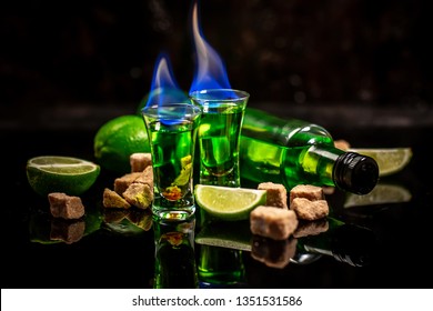 absinthe shots with sugar cubes. absinthe poured into a glass. bottle of absinthe with brown sugar and lime isolated on black background. space for text.