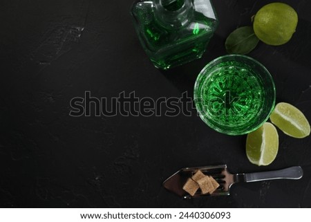 Absinthe, spoon, brown sugar and lime on black table, flat lay with space for text. Alcoholic drink