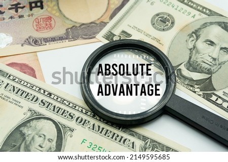 Absolute Advantage.Magnifying glass showing the words.Background of banknotes and coins.basic concepts of finance.Business theme.Financial terms.