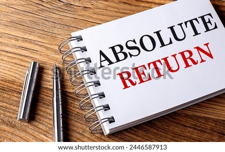 ABSOLUTE RETURN text on a notebook with pen on the wooden background . 