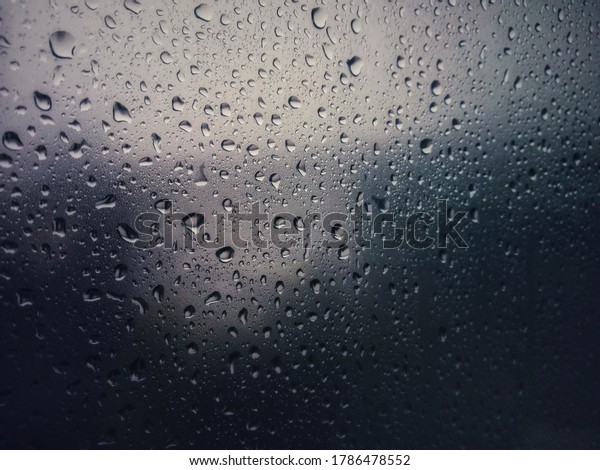 Abstact background : Rain\
drop on grass car window blurry with heavy rain, Driving in rain,\
rainy weather