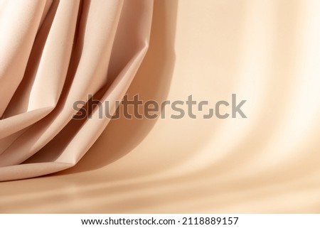Abstract 3d studio with draping silk fabric and shadow on cream beige pastel monochrome background for cosmetic product presentation. Empty room, scene, podium or stand with copy space.