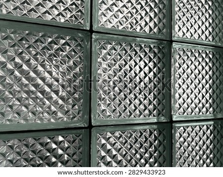 Abstract architectural background featuring clear textured glass tiles with repeating starburst details