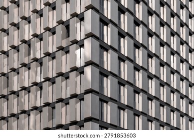 Abstract architectural background featuring a close-up of a modern skyscraper facade with a repeating geometric window pattern . Perfect for real estate, business, and construction concepts