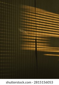Abstract architectural background featuring dramatic light and shadow play from window shutters on vertical wooden panels.