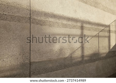 Abstract architectural background with sunlight and shadow on textured wall.