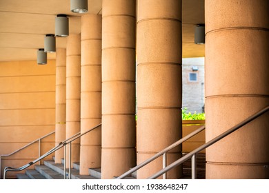 Abstract architectural row of columns pattern with hanging modern lamps lights and steps stairs staircase railing