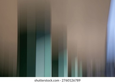 An abstract architectural study featuring rhythmic vertical lines that dissolve into a soft, blurred atmosphere. The cool teal and grey tones create a serene, contemplative, and sophisticated mood. By stripping away detail, the image emphasises form and motion, making it ideal for modern interior decor, corporate branding, or minimalist editorial layouts where a sense of 