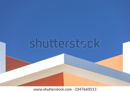 abstract architecture background. Close up geometric angular structure detail walls fragments. White, orange brown walls against blue sky. Contemporary minimalist architectural photography. Exterior.