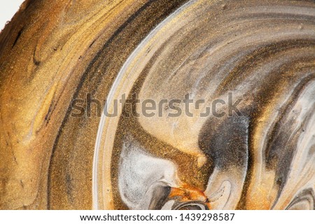 Abstract Art - close up of mixed golden metallic acrylic paint in a swirl. Glitters and sparkles and movement. Effect of old wood. Macro detail photo of my acrylic pouring artwork.