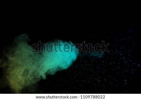  Abstract art colored powder on black background. Frozen abstract movement of dust explosion multiple colors on black background. Stop the movement of multicolored powder on dark background. 
