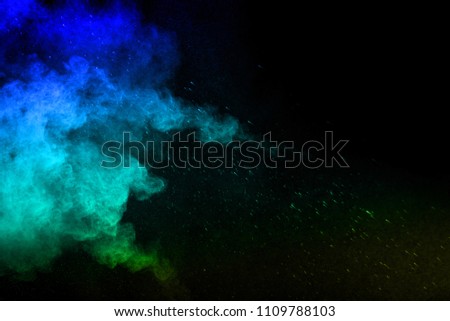  Abstract art colored powder on black background. Frozen abstract movement of dust explosion multiple colors on black background. Stop the movement of multicolored powder on dark background. 

