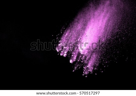 Abstract art pink powder on black background. Frozen abstract movement of dust explosion pink colors on black background. Stop the movement of pink powder on dark background.