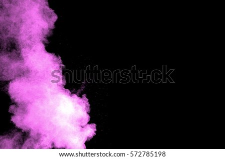 Abstract art pink powder on black background. Frozen abstract movement of dust explosion pink colors on black background. Stop the movement of pink powder on dark background.